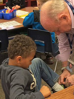 Grandpa Dale stops to help first-grader Cameron Robydek tie his shoe