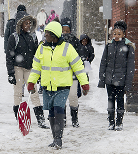 Eason approaches traffic on Wealthy Street SE to help MLK students cross that busy thoroughfare