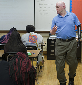 Algebra class at Innovation Central High School, with Colonel Bryan Forney explaining a math problem