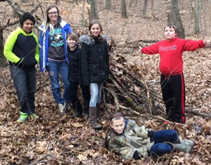 From left, fifth-grader Kahari Sprague, parent Jessica Rogers, and fifth-graders Christopher Rogers, Peyton Rike, Andrew Leet and Hope Kilbourn (front) with the lean-to they built