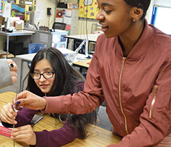 Seventh-graders Samatha Benitez and Camiyah Blackman try to figure out how to balance six nails atop one nailhead, a challenge from Mayor Stephen Kepley