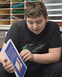 Freshman Logan Evans shares his book with second-graders