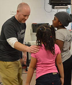 Kelly McGee, media specialist and theater director, tags a second-grader during his improv session