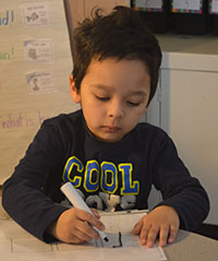 Kindergartner Emiliano Castro, an ELL student, practices spelling