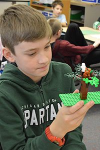 Mason Dennis creates a Lego tree for his group’s claymation video