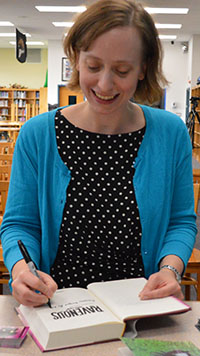 MarcyKate Connolly signs a book for the Lee Middle-High School media center