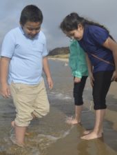 Bravely dipping their feet into the cold water are, left, Alan Ramirez-Becerra and Naudia Radilla-Diego 