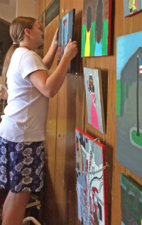 Middle-schooler Elinor Edlund hangs her painting in Fountain Street Church downtown (courtesy photo)