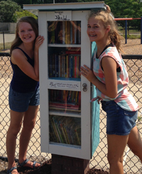 Lily Howland, left, and Chloe Grifhorst designed and built a Little Free Library to share their love of reading with the community