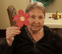 American House resident Vergie Schuitema shows off her flower craft