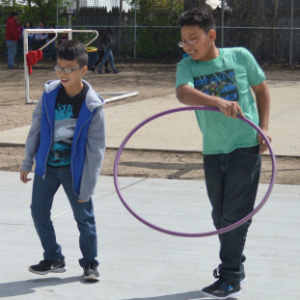 Fifth-graders Eduardo Mazariegos and Ambrosio Lemus play with hula hoops on the new concrete surface