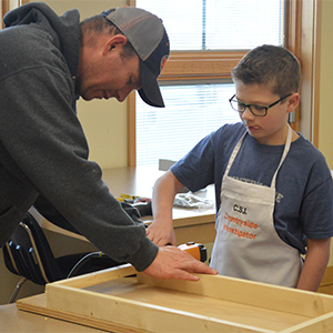 Morgan Kaiser uses a nail gun with volunteer Jason Curtis