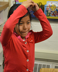  Enadina Mencho-Vail acts out flying a kite after reading about it