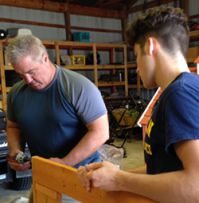 Student Josh Carter assembles a playhouse with Doug Gallup, Byron Center Public Schools Director of Transportation