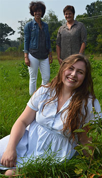 Senior Pearl Chapman, foreground, with teachers Lynn Cvengros (left) and Dolores Keeley amid raspberry and blueberry rows on Forest Hills Eastern High land. The berries were planted through a grant from the Forest Hills Education Foundation as a “seed” project of the edible schoolyard