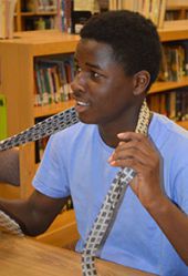 Seventh-grader Justin Jackson practices tying