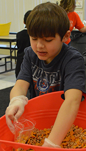 Fourth-grader Jake Agema packs trail mix for Kids Food Basket