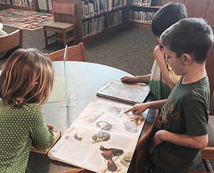 Students gather around books at an East Grand Rapids elementary school library