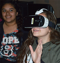 Seventh-grader Stacie Aguirre tries a virtual reality device while learning about software engineering