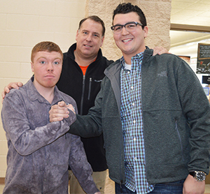 Byron Center High School senior Nick Baker, at right, greets sophomore Hunter James VandeVelde and teacher Doug Takens