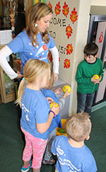 Teacher Kate Johnson helps her students as they prepare for their turns at bocce ball