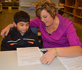 Third-grade student Daniel Rangel-Zavala works with tutor Joy Howard, who also is a paraprofessional for Kelloggsville Public Schools