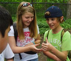 Fifth-grade students Roman Gendron and Cienna Coats check out a walnut found at the park