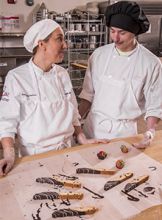 Sarah Waller and her student add the final touches to a batch of biscotti