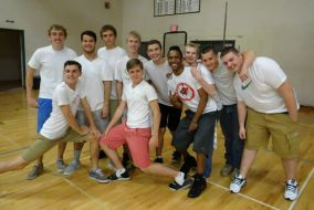 Gloire and his high school friends strike pose on the gymnasium floor