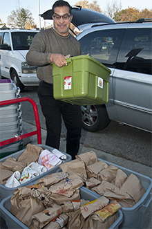 John Matias loads up supplies and food that will be distributed to students who need them