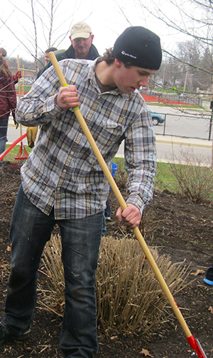 Wild and Dirty club members and volunteers clean up the East Grand Rapids High School landscape recently, prepping it for installation of native plants.