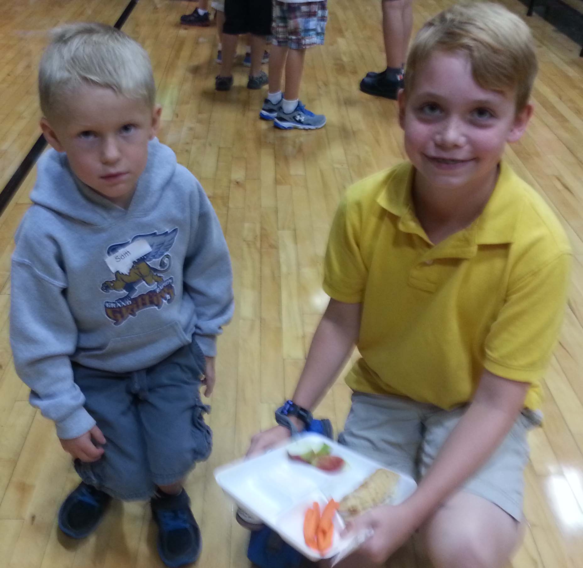 Fifth-grade Ben Blanchard helps Sam Brundin with his lunch tray