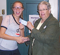 Delaney Buchanan presents a check to her grandmother, Darlene Yasick, for the Steps for Stevie nonprofit