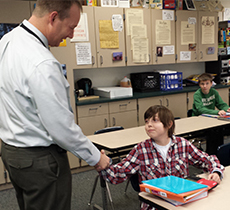 Principal Mike Ramm congratulates Devon as he takes his seat in U.S. history class