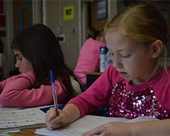 Alayna Cook, front, and Naliya Clark work on their essays