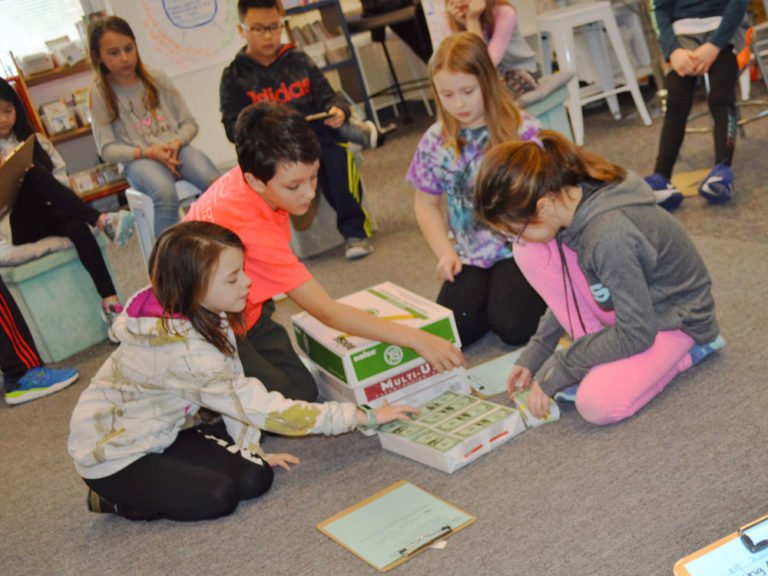 Bridget Bennett’s fourth-graders use the “fishbowl” style of problem-solving to figure out how to fit a million dollar bills into a box. Students are from left: Aubrey Sieler, Sam Bauchan, Fiona Overdevest and Mady Scarlato