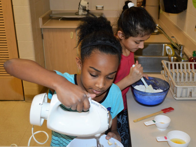 Tamyah Yarbrough, left, and Evelyn Reyes mix up a batch of best-selling oatmeal cookies
