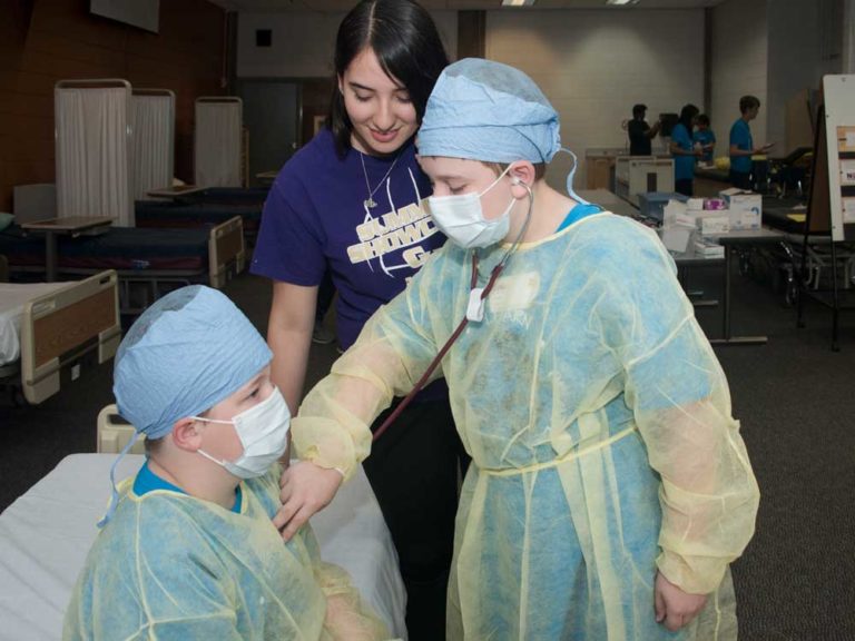 Murphy Hossink, sixth grade, Highlands Middle; Camp volunteer Naideli Loyo, senior, Wyoming High; and James Dubin, eighth grade, North Rockford Middle, learn how to listen to the heart
