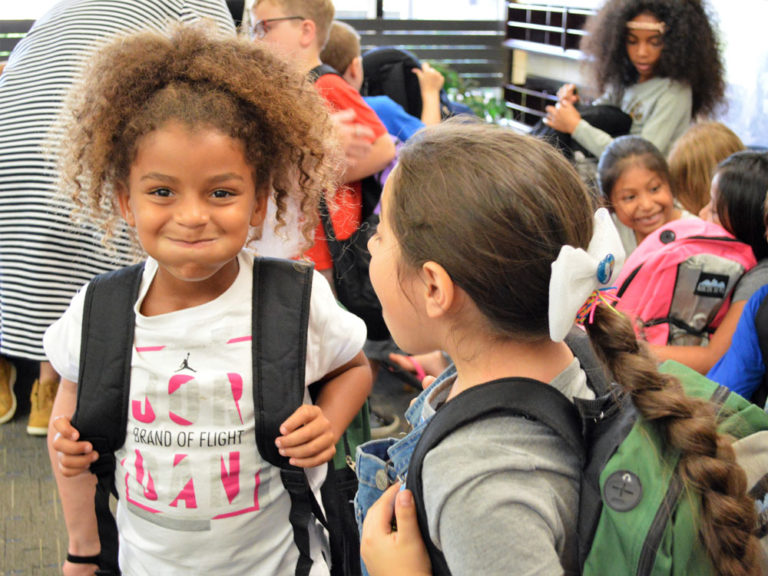 First-graders try on new donated backpacks