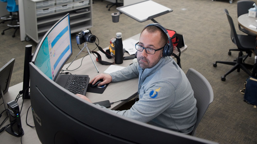 Digital Animation and Game Instructor Marc Petz operates multiple screens at the Virtual Open House while presenting his program