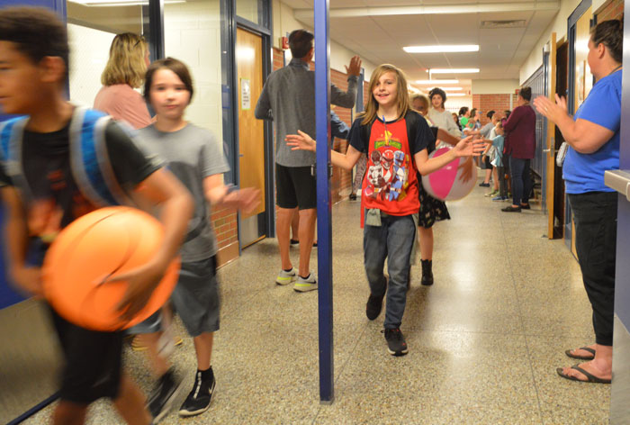 Ryan Cuper high-fives both sides as he and other fifth-graders walk the halls of Appleview Elementary one last time 