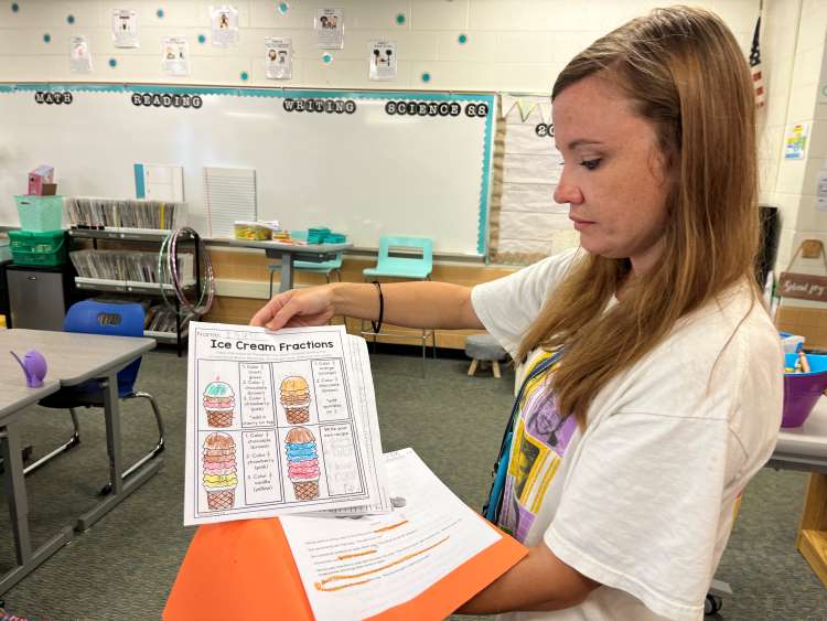 Teaching assistant Kayleigh Bisel demonstrates how Jumpstart students work on fractions