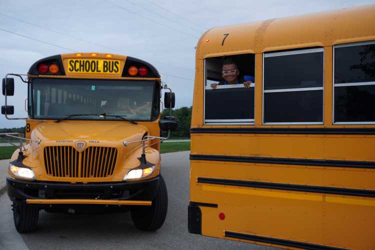 Jackson Vanderkoi peeks from a bus window on his first day of seventh grade at Kenowa Hills Middle School 