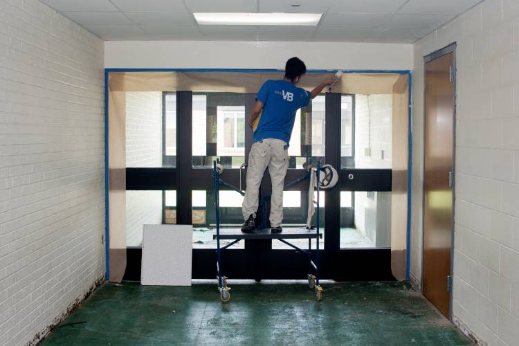 A painter carefully paints the edge of the new doorway
