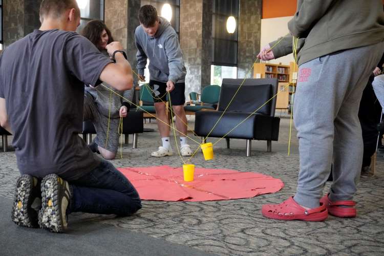 One group used two string-and-rubber band contraptions between four people to safely transfer the ‘toxic’ cups 
