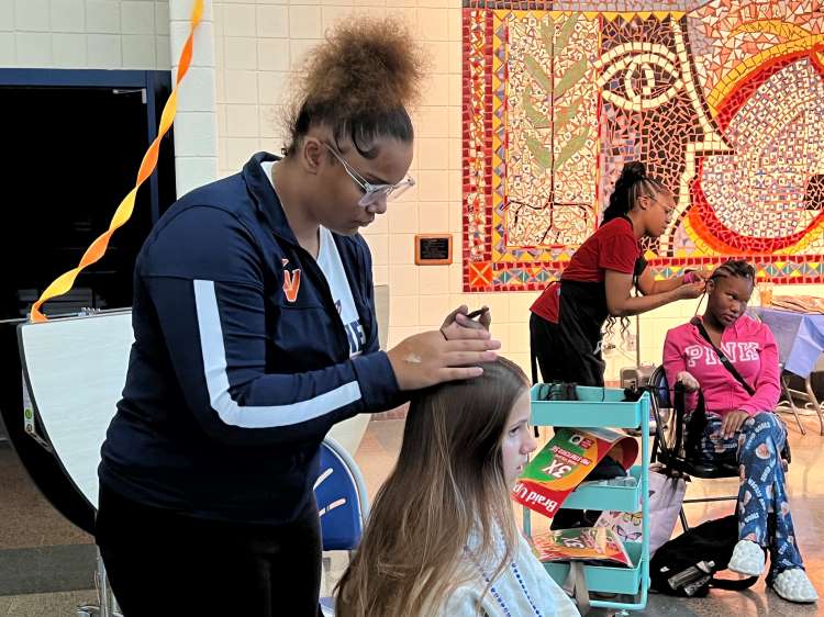 54th Street Academy senior Renae Blair works on braiding hair