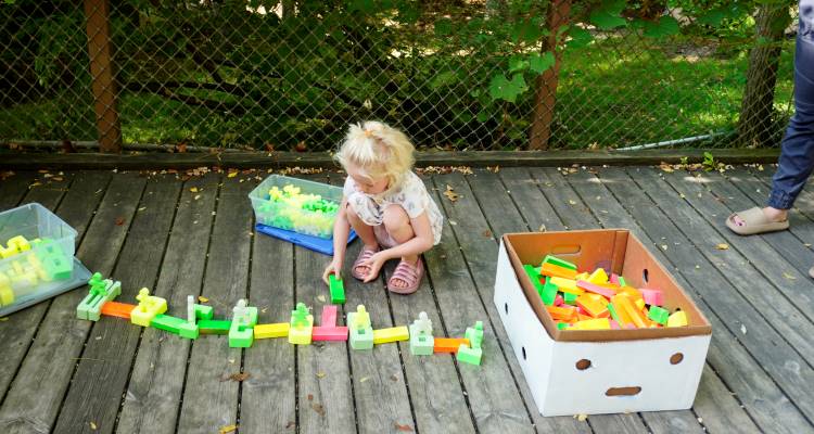 Three-year-old Ellie Warners plays with blocks at the Kent ISD station 