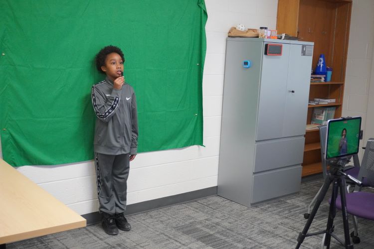 Fourth-grader David Hughes gives an update on district sports