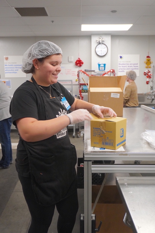 Maria sets up a food packing session at Kids’ Food Basket
