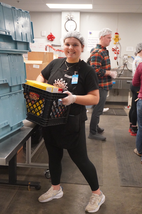 Maria Christopoulos leads a food packing session at Kids’ Food Basket